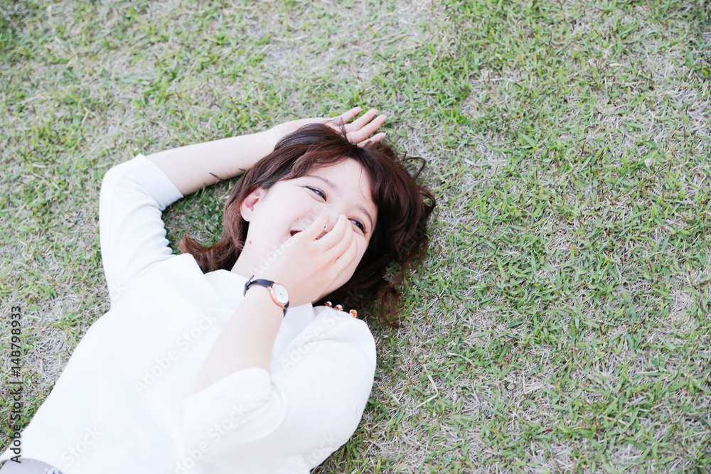 young attractive asian woman Lie on the lawn young attractive asian woman Lie on the lawn