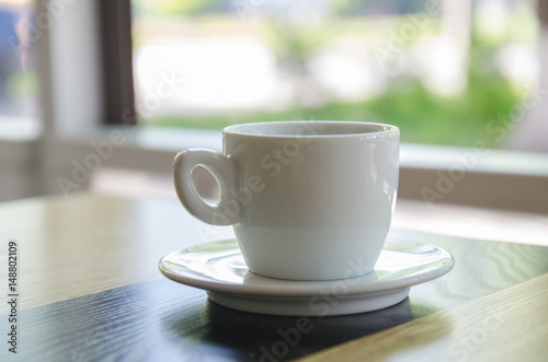 A cup of black coffee in a white cup on wooden table