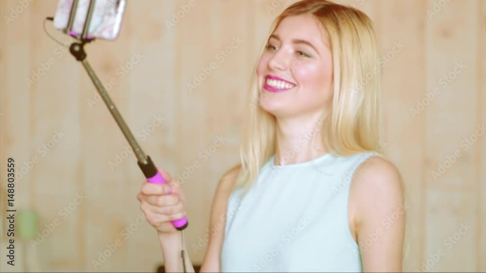 Attractive blonde woman, technology and leisure concept - happy female taking selfie on smartphone at home Attractive blonde woman, technology and leisure concept - happy female taking selfie on smartphone at home