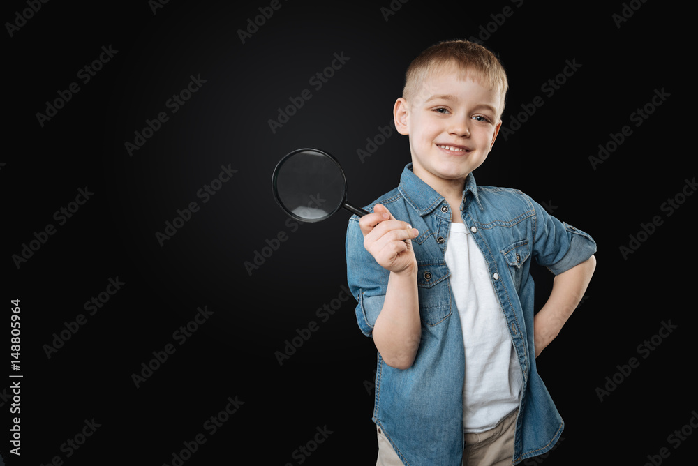 Positive delighted kid putting his left hand on the belt Positive delighted kid putting his left hand on the belt