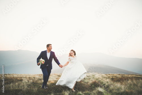 Happy beautiful wedding couple bride and groom at wedding day outdoors on the mountains rock. Happy marriage couple outdoors on nature, soft sunny lights