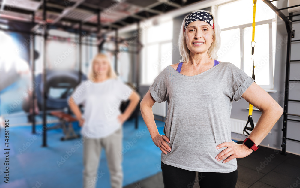 Pleasant sporty woman resting hands on her hips