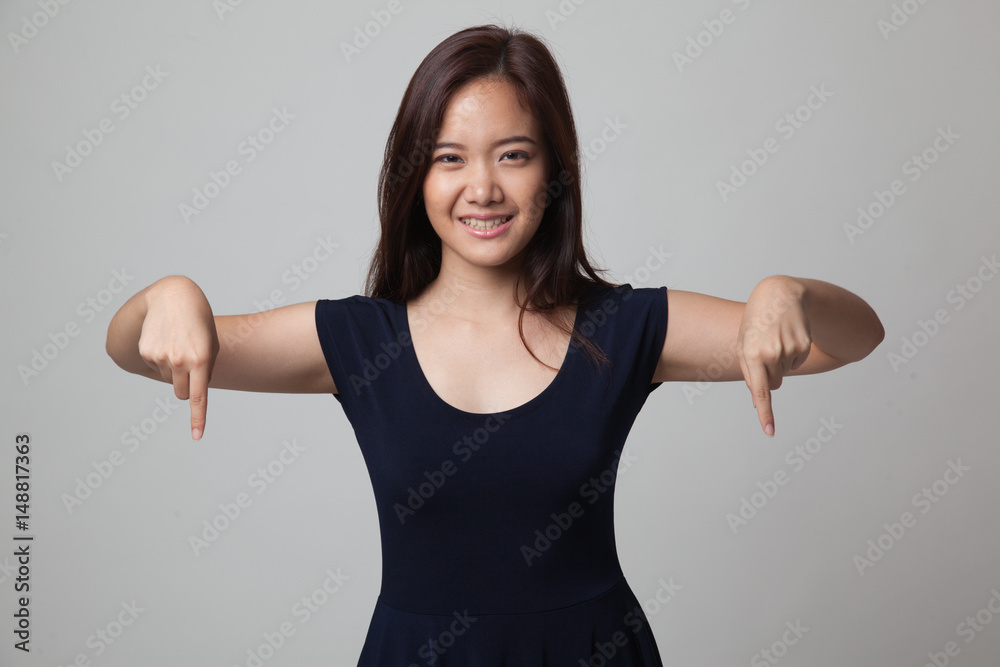 Beautiful young Asian woman point down to blank space. Beautiful young Asian woman point down to blank space.