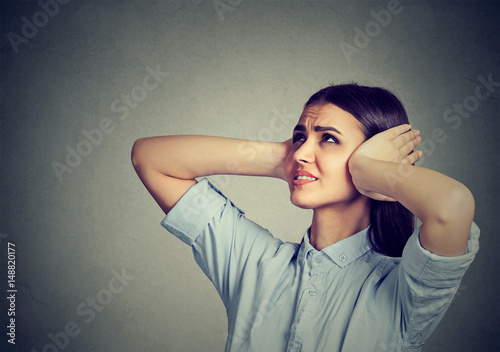 Fotografie Stressed frustrated woman covering her ears with hands.