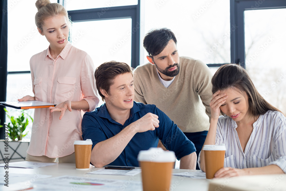 group of young business people looking at colleague on small business meeting group of young business people looking at colleague on small business meeting