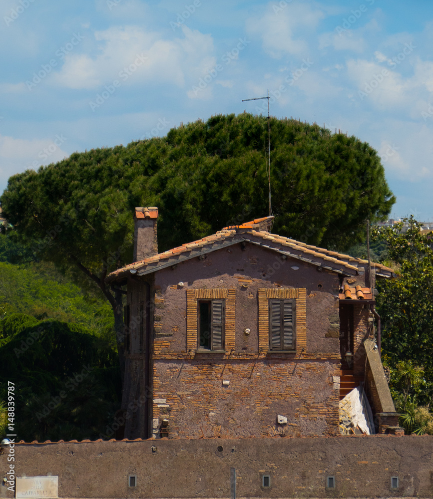 włoski murowany domek na tle zielonych drzew i błękitnego nieba