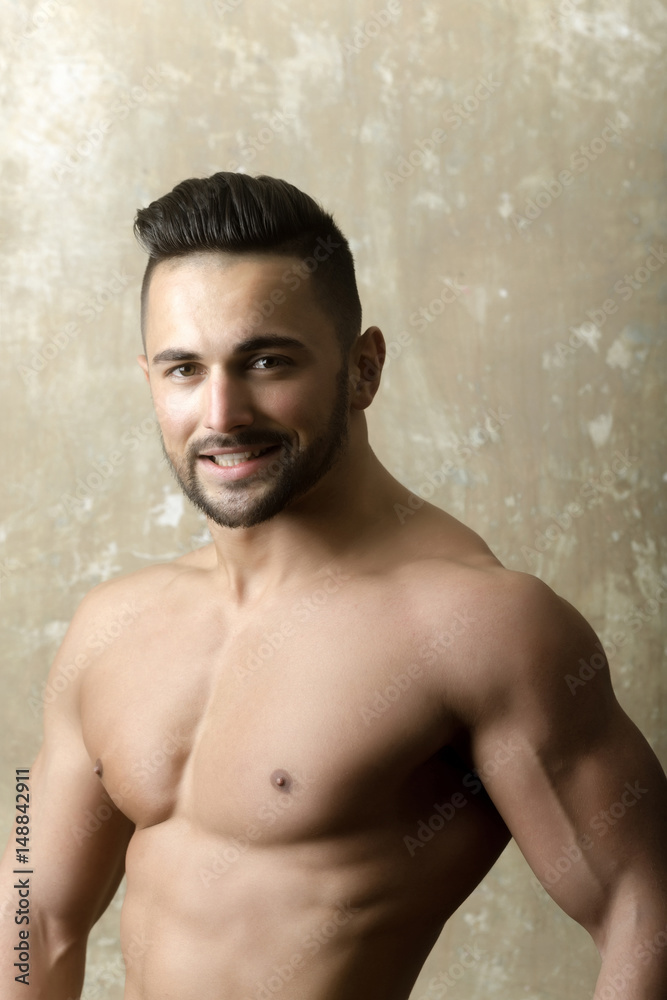 Happy handsome man smiling with fit muscular torso