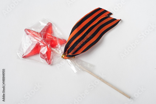 Candy in the shape of a star, a red candy on a stick in a bag, photo