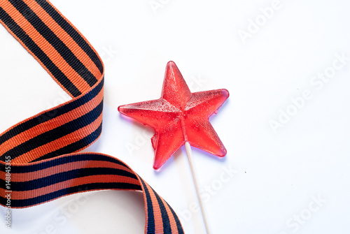 Candy in the shape of a star, a red candy on a stick, photo