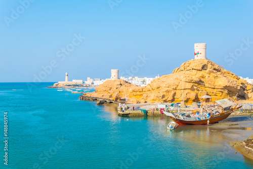 View of the Al Ayjah town, two watchtowers and a dhow under repair from the Khor Al Batah bridge in Sur, Oman photo