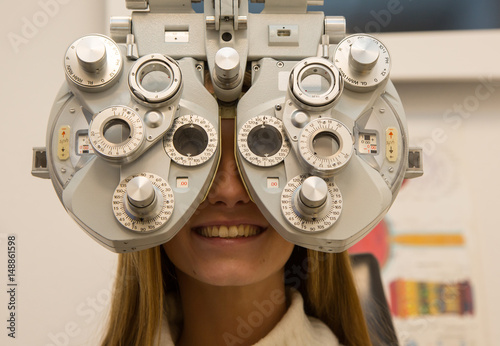 Customer in opticians shop testing eyesight in phoropter photo