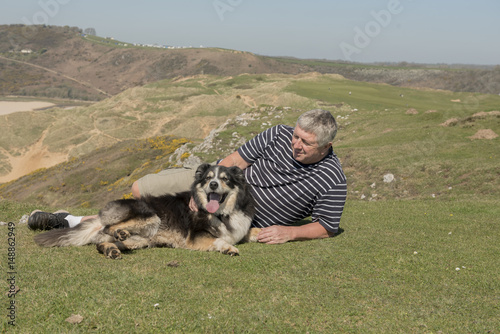Happy mature man outdoors with sheep dog