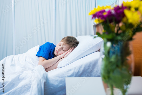 Cute little sick boy sleeping in hospital bed
