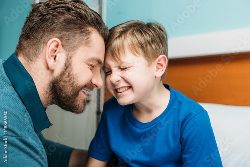portrait of smiling dad and son in hospital chamber