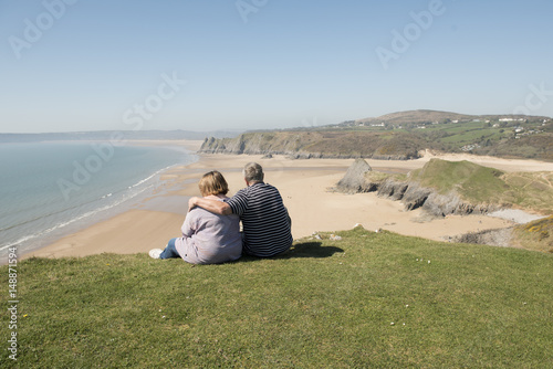 Happy mature couple outdoors over looking a beach landscape view 