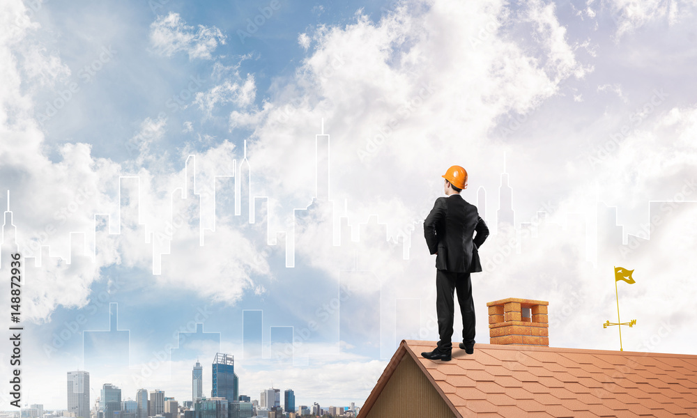 Engineer man standing on roof and looking away. Mixed media Engineer man standing on roof and looking away. Mixed media