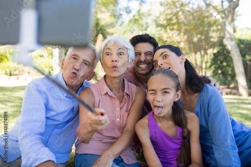 Family making funny faces while taking a selfie in the park