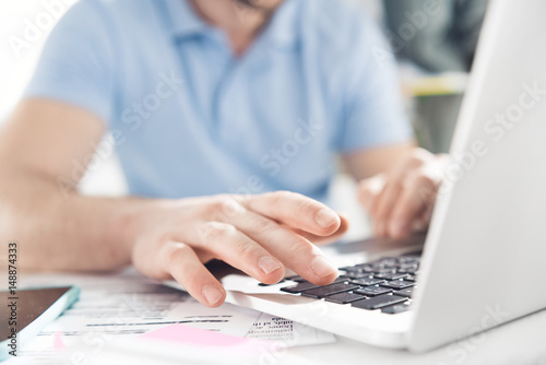 close up of casual businessman working on laptop at modern office, business men computer