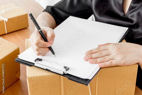 Woman signs clipboard for delivery