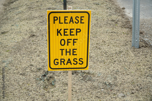 please keep off grass warning sign on the yellow meadow