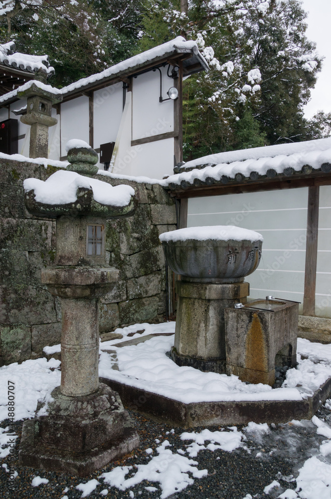 A stone lantern and moss covered with snow on top. A stone lantern and moss covered with snow on top.