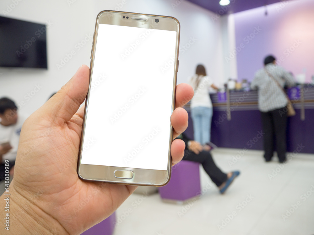 Man hand holding touch screen smart phone with white blank empty screen (ISOLATED), blurred fast food restaurant for background.
