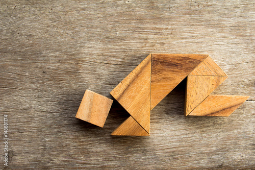 Wooden tangram puzzle in man crouch shape background
