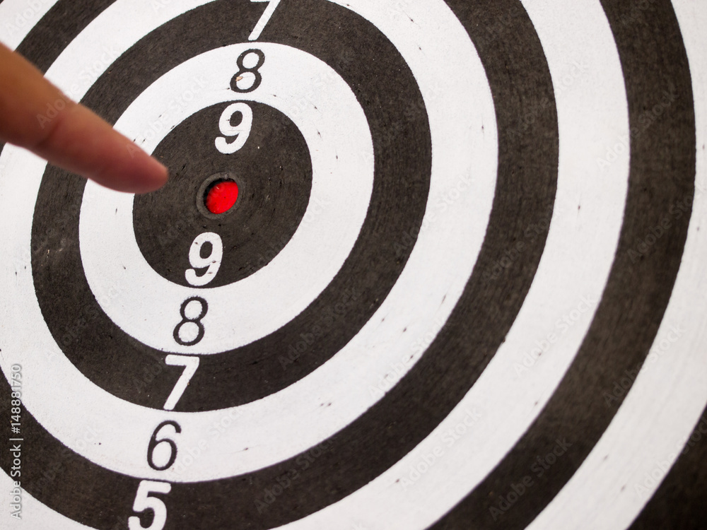 Black and white dart with hand point at center (Concept for target, achievement, business focus) Black and white dart with hand point at center (Concept for target, achievement, business focus)