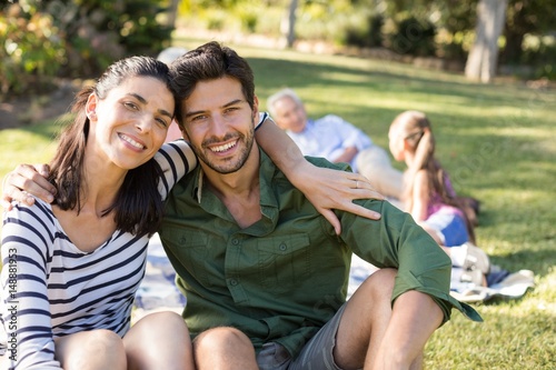 Portrait of happy couple sitting in the park