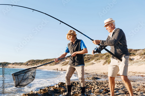 Senior man fishing with his grandson