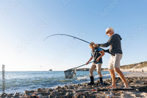 Senior man fishing with his grandson