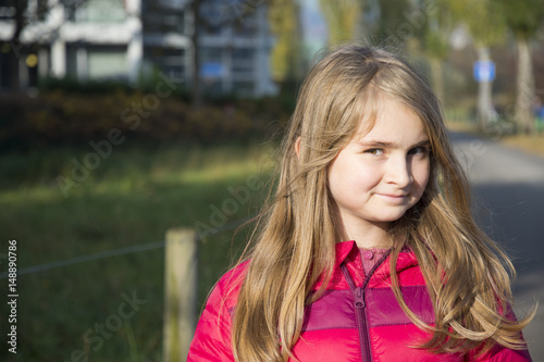 Cute little blonde girl walking in a park on a nice sunny autumn afternoon © cwzahner