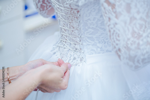 Невесте затягивают корсет. photo