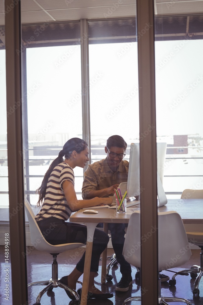 Businessman working with female colleague in office Businessman working with female colleague in office