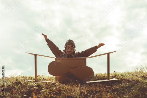 Konstfotografi side view vintage pilot boy flight by imagination on cardboard plane outdoor
