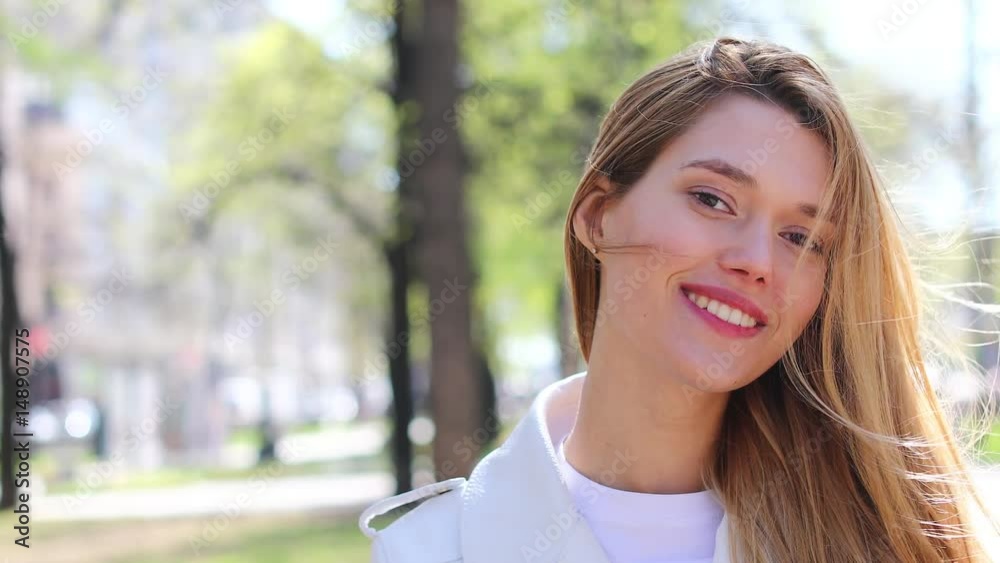 Hair Model. Smiling blonde woman showing off her long lush hair in summer park Hair Model. Smiling blonde woman showing off her long lush hair in summer park