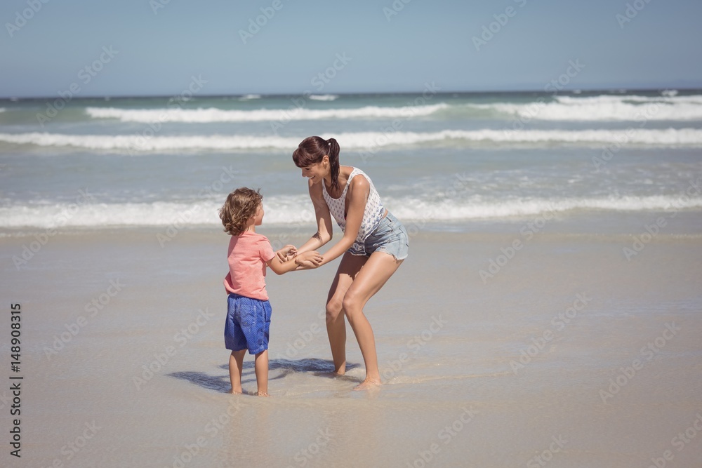 Happy son enjoying with mother on shore at beach