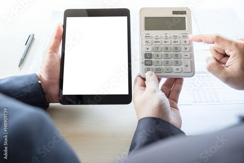 Fototapeta Naklejka Na Ścianę i Meble -  Businessman analysis on calculator, new plan financial graph data with business colleagues using digital tablet for estimation at the office, invesment concept