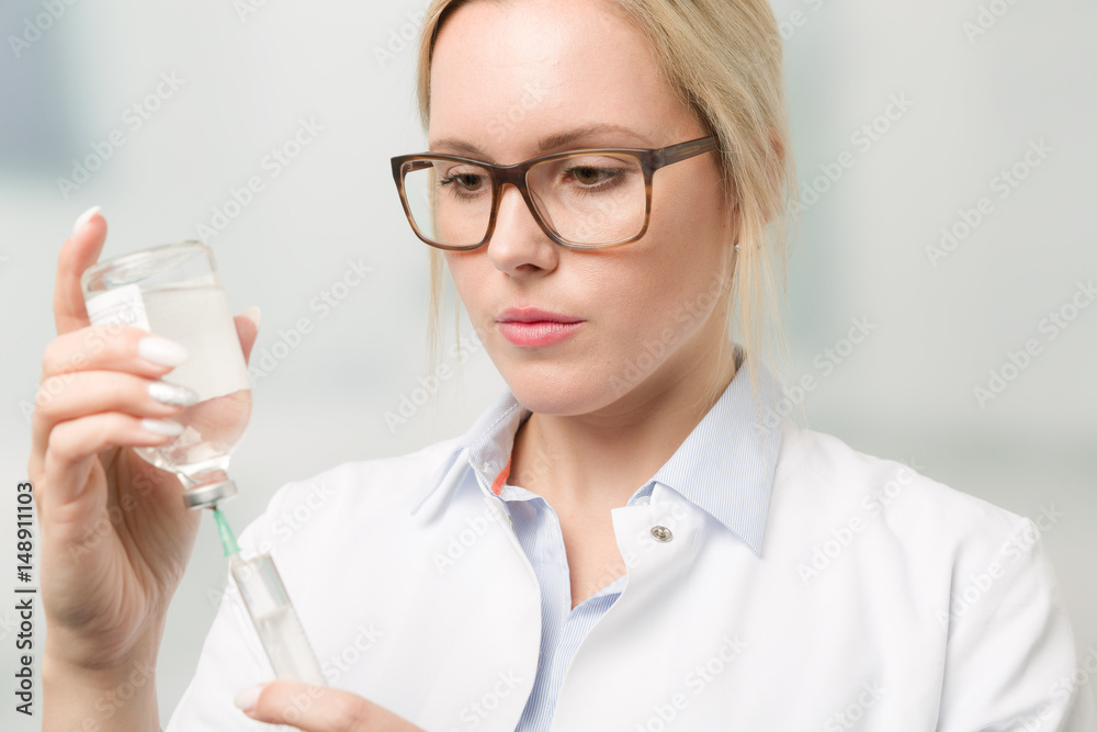 Junge hübsche Ärztin mit Serumflasche und Spritze Junge hübsche Ärztin mit Serumflasche und Spritze