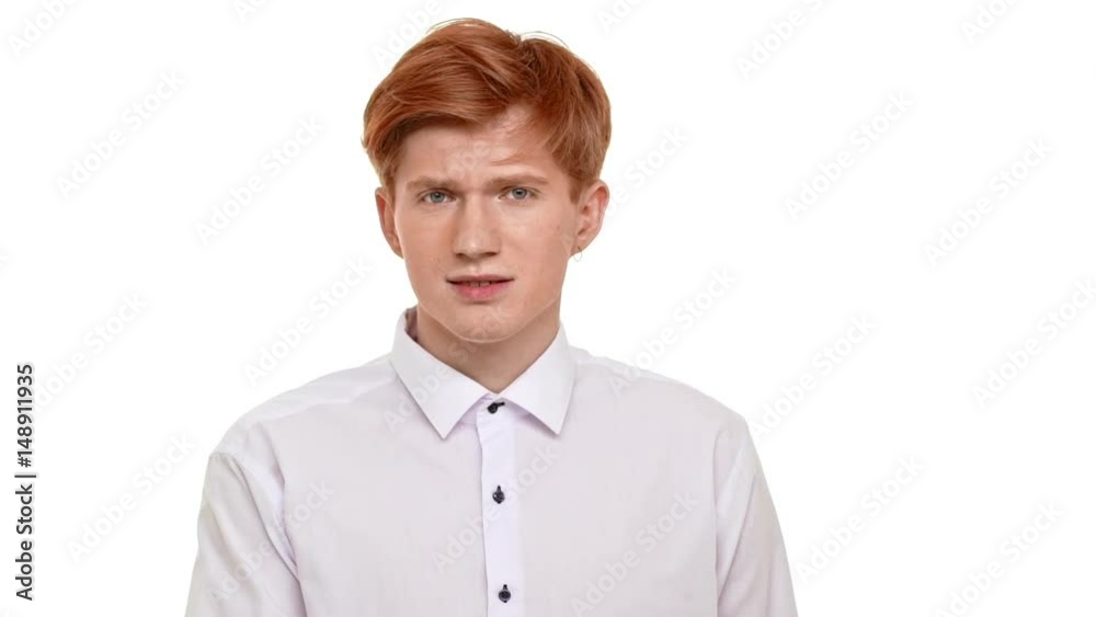 Caucasian foxy young man standing on white background standing at loss on white background in slowmotion Caucasian foxy young man standing on white background standing at loss on white background in slowmotion