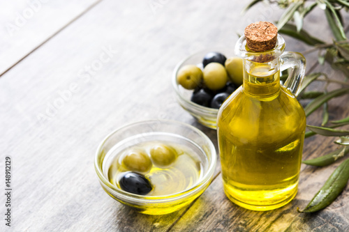 Virgin olive oil in a crystal bottle on wooden background 