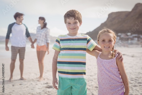 Portrait of smiling siblings with parents behind photo