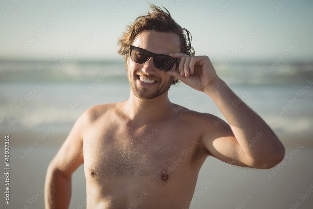 Portrait of shirtless man wearing sunglasses at beach Portrait of shirtless man wearing sunglasses at beach