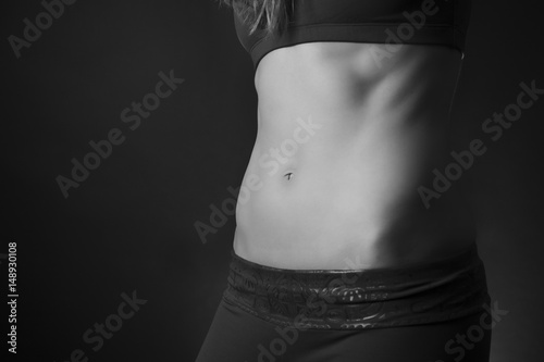 Female abdominal muscles on black background in black and white