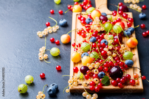Fresh berries on wooden cutting board. Copy space