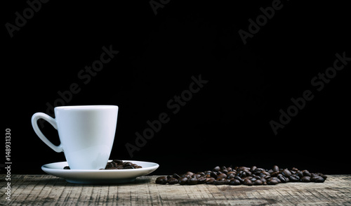 Café expresso sur une vielle table en bois, sous fond noir photo