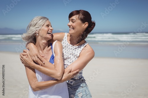 Happy woman with her mother standing at beach