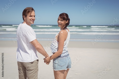 Portrait of young couple holding hands at beach
