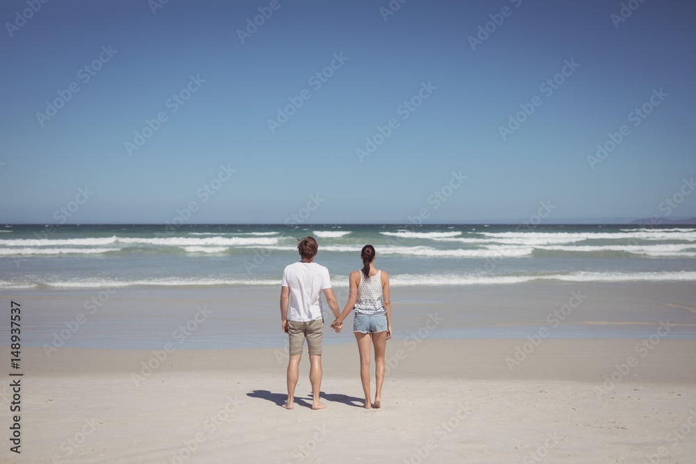 Rear view of couple holding hands at beach Rear view of couple holding hands at beach