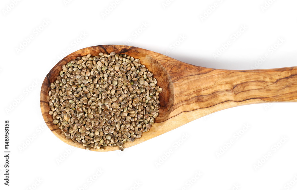 pile hemp seeds with wooden spoon isolated on white background